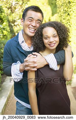 Portrait of a mid adult man holding a young woman View Large Photo Image Stock Image - Portrait of a mid adult man holding a young woman. Fotosearch