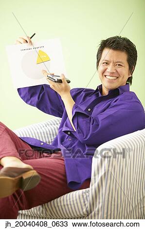 Portrait of a mid adult man sitting holding a palmtop and a graph View Large Photo Image Stock Image - Portrait of a mid adult man sitting holding a palmtop and a graph. Fotosearch