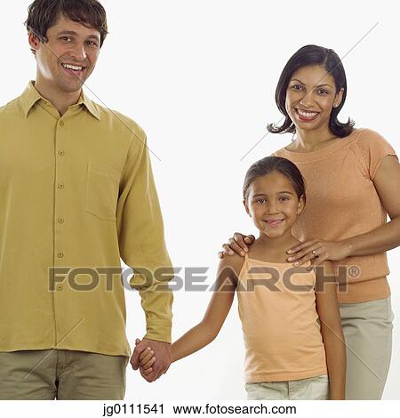 Stock Image - Portrait of a young couple and their daughter standing together looking at camera. Fotosearch