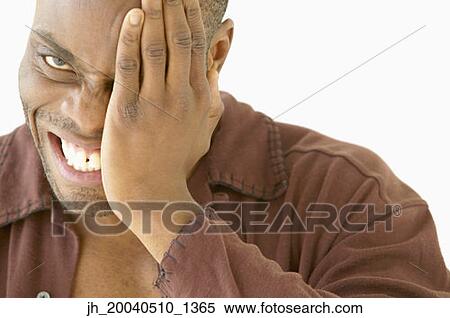 Portrait of a young man covering his eye with his hand View Large Photo Image Stock Photography - Portrait of a young man covering his eye with his hand. Fotosearch