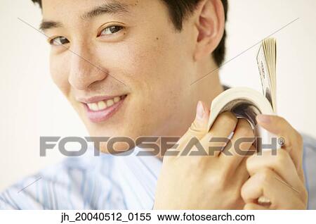 Portrait of a young man flicking a stack of bank notes View Large Photo Image Stock Photography - Portrait of a young man flicking a stack of bank notes. Fotosearch