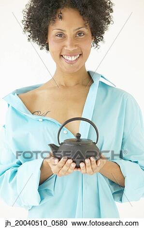 Portrait of a young woman holding a kettle smiling View Large Photo Image Stock Image - Portrait of a young woman holding a kettle smiling. Fotosearch