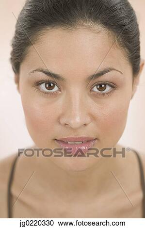 Portrait of a young woman looking at camera View Large Photo Image Stock Image - Portrait of a young woman looking at camera. Fotosearch