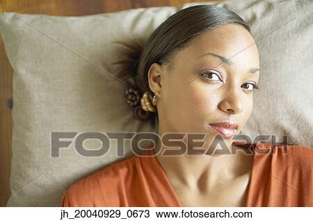 Portrait of a young woman lying down View Large Photo Image Stock Image - Portrait of a young woman lying down. Fotosearch