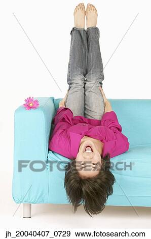 Portrait of a young woman lying on a couch View Large Photo Image Stock Photo - Portrait of a young woman lying on a couch. Fotosearch