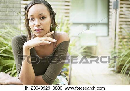 Stock Image - Portrait of a young woman with her hand on her chin. Fotosearch