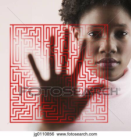 Stock Photograph - Portrait of a young woman with her hand on a diagram of a maze. Fotosearch