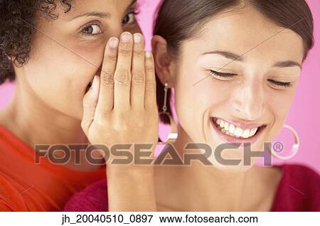 Portrait of a young women whispering into a woman's ear View Large Photo Image Stock Photo - Portrait of a young women whispering into a woman's ear. Fotosearch