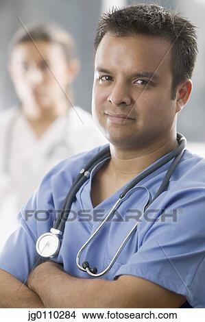 Portrait of male medical personnel standing with arms folded looking at camera View Large Photo Image Picture - Portrait of male medical personnel standing with arms folded looking at camera. Fotosearch