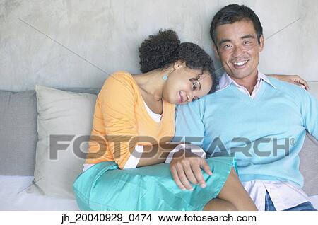 Portrait of mid adult man sitting with a young woman close to him View Large Photo Image Picture - Portrait of mid adult man sitting with a young woman close to him. Fotosearch