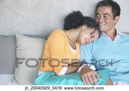 Portrait of mid adult man sitting with a young woman close to him View Large Photo Image Stock Photo - Portrait of mid adult man sitting with a young woman close to him. Fotosearch