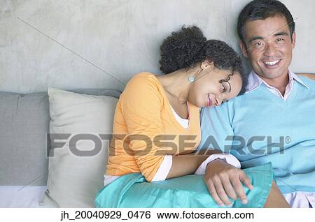 Portrait of mid adult man sitting with a young woman close to him View Large Photo Image Stock Photograph - Portrait of mid adult man sitting with a young woman close to him. Fotosearch