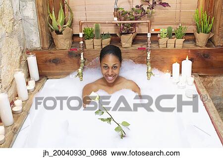 Portrait of young woman in a bubble bath smiling View Large Photo Image Stock Photo - Portrait of young woman in a bubble bath smiling. Fotosearch