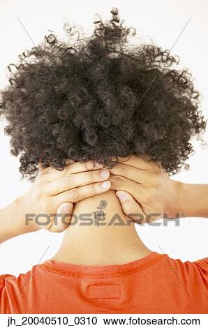 Rear view of a young woman holding her neck View Large Photo Image Stock Image - Rear view of a young woman holding her neck. Fotosearch