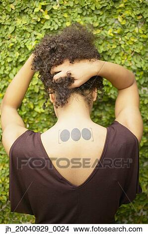 Rear view of a young woman with tattoo on her neck View Large Photo Image Picture - Rear view of a young woman with tattoo on her neck. Fotosearch