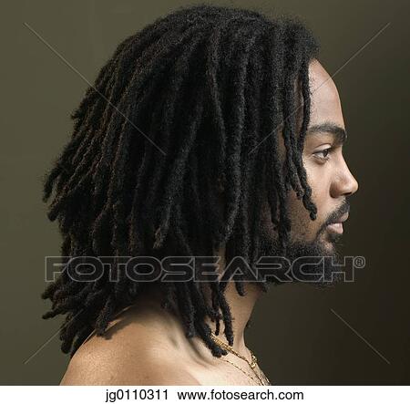 Stock Image - Side profile of a young man with dreadlocks. Fotosearch