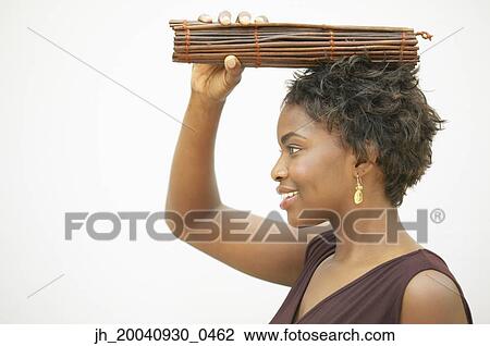 Side profile of a young woman holding incense sticks over her head View Large Photo Image Stock Image - Side profile of a young woman holding incense sticks over her head. Fotosearch
