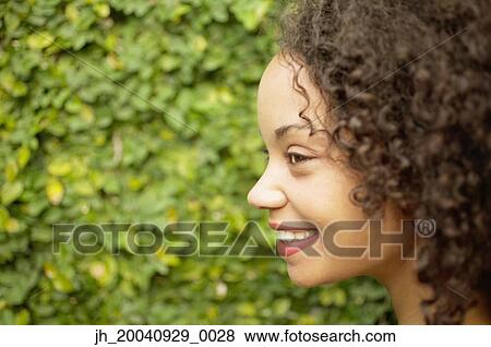 Side profile of a young woman smiling View Large Photo Image Stock Photo - Side profile of a young woman smiling. Fotosearch