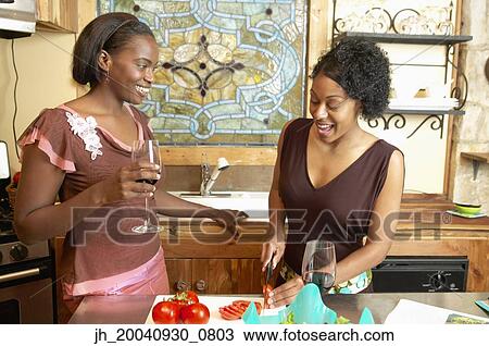 Two young women talking to each other in a kitchen View Large Photo Image Stock Image - Two young women talking to each other in a kitchen. Fotosearch