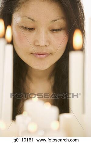 Woman looking at lit candles on a cake View Large Photo Image Stock Image - Woman looking at lit candles on a cake. Fotosearch