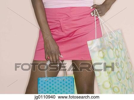 Woman standing holding shopping bags View Large Photo Image Stock Image - Woman standing holding shopping bags. Fotosearch