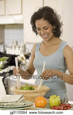 Woman tossing salad in a salad bowl View Large Photo Image Picture - Woman tossing salad in a salad bowl. Fotosearch