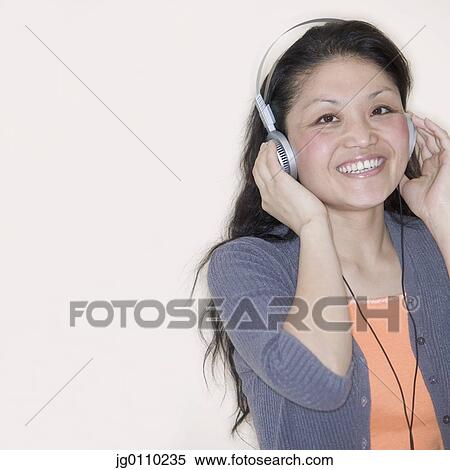 Stock Photography - Woman wearing headphones smiling. Fotosearch