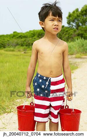 Young boy carrying two buckets at the beach View Large Photo Image Picture - Young boy carrying two buckets at the beach. Fotosearch