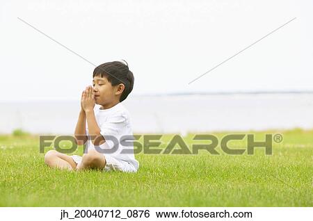 Young boy meditating on the lawn View Large Photo Image Stock Photograph - Young boy meditating on the lawn. Fotosearch