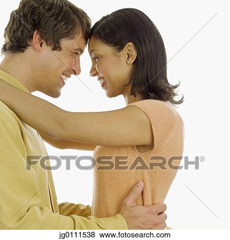 Young couple holding each other smiling View Large Photo Image Stock Photo - Young couple holding each other smiling. Fotosearch