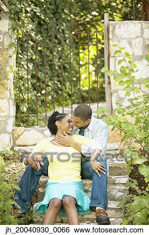 Young couple sitting together on stairs kissing View Large Photo Image Stock Photograph - Young couple sitting together on stairs kissing. Fotosearch