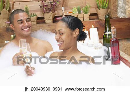 Young couple together in a bubble bath toasting with champagne View Large Photo Image Stock Image - Young couple together in a bubble bath toasting with champagne. Fotosearch