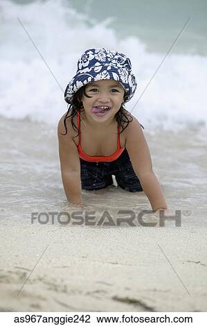 Stock Image - Young girl lying on the beach. Fotosearch