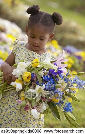 Young girl standing in a field holding flowers View Large Photo Image Stock Photo - Young girl standing in a field holding flowers. Fotosearch