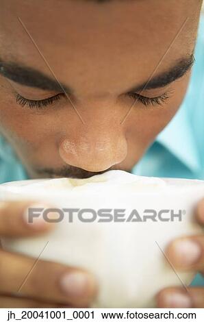 Young man drinking from a cup View Large Photo Image Stock Image - Young man drinking from a cup. Fotosearch
