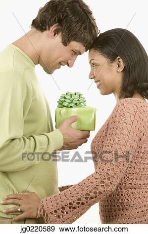 Stock Photo - Young man giving a young woman a present. Fotosearch