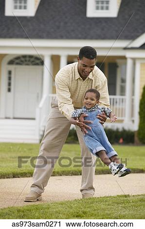 Young man holding a child in his arms View Large Photo Image Stock Image - Young man holding a child in his arms. Fotosearch