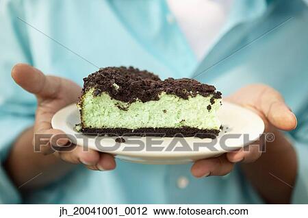 Young man holding a plate with a piece of cake View Large Photo Image Stock Image - Young man holding a plate with a piece of cake. Fotosearch