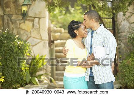 Young man kissing a young woman on her forehead View Large Photo Image Stock Image - Young man kissing a young woman on her forehead. Fotosearch
