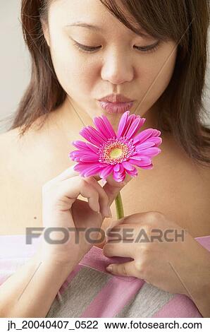 Young woman blowing a flower View Large Photo Image Stock Image - Young woman blowing a flower. Fotosearch