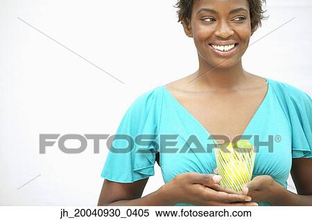 Young woman holding a glass filled with kiwi fruit View Large Photo Image Stock Photography - Young woman holding a glass filled with kiwi fruit. Fotosearch