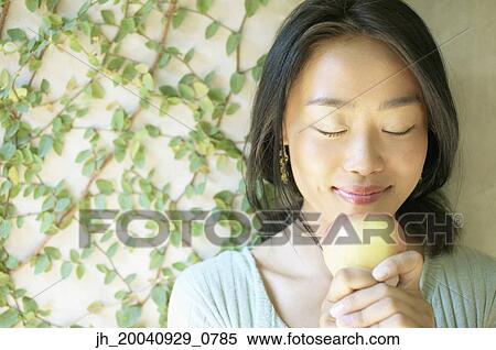 Young woman holding am apple with eyes closed View Large Photo Image Stock Photography - Young woman holding am apple with eyes closed. Fotosearch