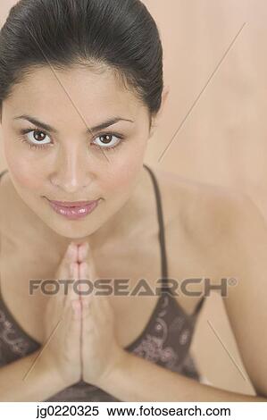 Young woman looking at camera with her hands together View Large Photo Image Stock Photography - Young woman looking at camera with her hands together. Fotosearch