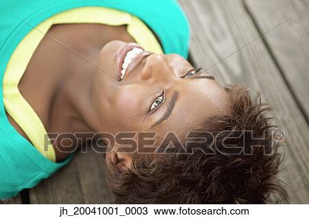 Young woman lying on the floor View Large Photo Image Stock Image - Young woman lying on the floor. Fotosearch