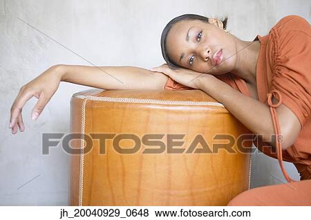 Young woman resting on a stool View Large Photo Image Stock Photo - Young woman resting on a stool. Fotosearch