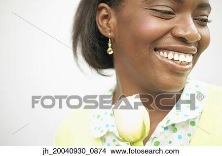 Young woman smiling holding a rose View Large Photo Image Picture - Young woman smiling holding a rose. Fotosearch