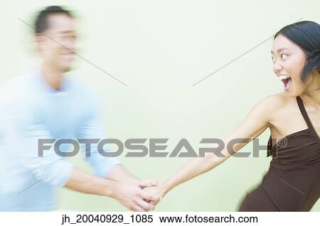 Young women and a mid adult man walking together holding hands View Large Photo Image Stock Photography - Young women and a mid adult man walking together holding hands. Fotosearch