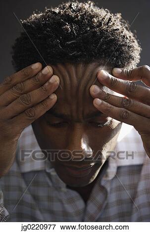 Close-up of a mid adult man holding his head View Large Photo Image Stock Photo - Close-up of a mid adult man holding his head . Fotosearch