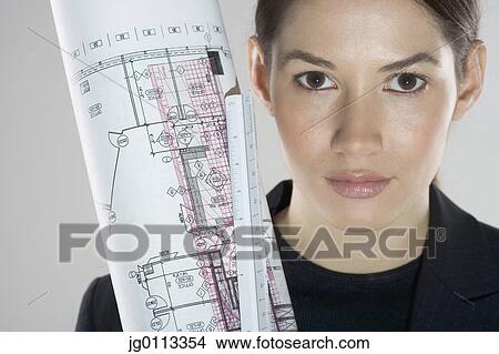Picture - Close-up of a young woman holding blueprints. Fotosearch