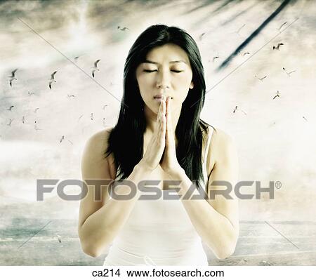 Close-up of a young woman praying View Large Photo Image Picture - Close-up of a young woman praying. Fotosearch